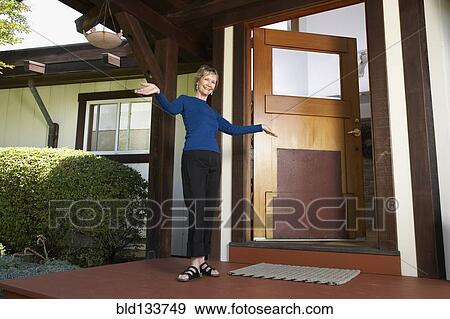 Stock Photo - Senior Caucasian woman standing on front porch. Fotosearch