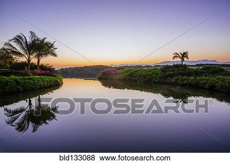 Sky reflected in still tropical lake View Large Photo Image Stock Photo - Sky reflected in still tropical lake. Fotosearch