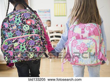 Stock Photography - Students holding hands in classroom. Fotosearch