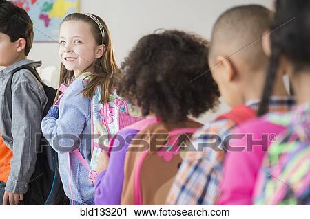 Stock Image - Students standing in line in classroom. Fotosearch