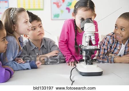 Stock Photo - Students using microscope in classroom. Fotosearch