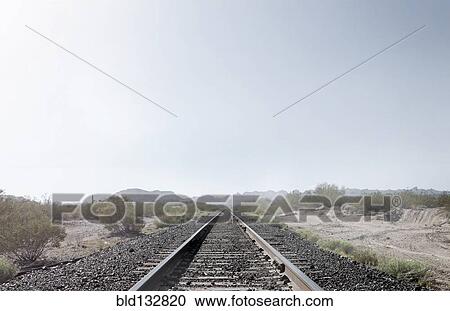 Stock Image - Train tracks in dusty rural landscape. Fotosearch