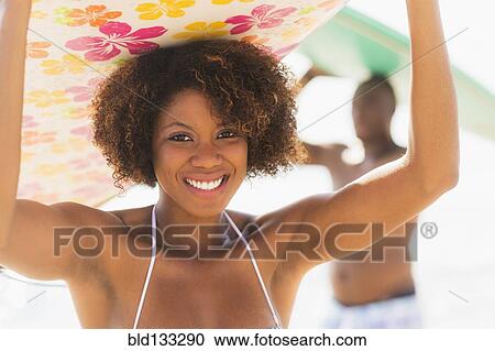 Woman carrying surfboard on beach View Large Photo Image Stock Image - Woman carrying surfboard on beach. Fotosearch