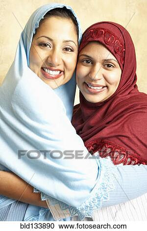 Stock Image - Women in headscarves hugging. Fotosearch