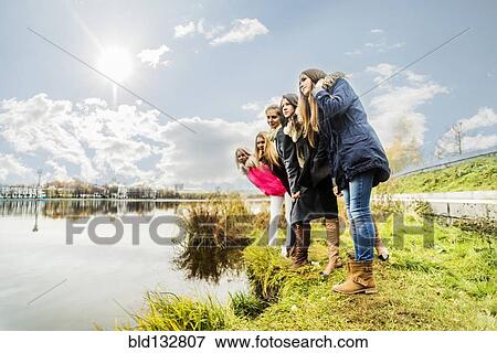 Stock Photo - Women overlooking still river. Fotosearch