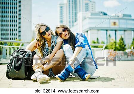 Women sitting on city street View Large Photo Image Picture - Women sitting on city street. Fotosearch