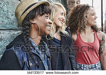 Stock Photo - Women smiling together on city street. Fotosearch