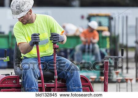 Worker operating machinery on construction site View Large Photo Image Stock Photography - Worker operating machinery on construction site. Fotosearch