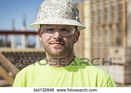 Stock Photograph - Worker smiling on construction site. Fotosearch