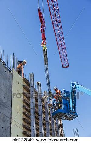 Stock Photo - Workers on concrete wall form on construction site. Fotosearch