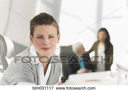 Businesswoman smiling in meeting View Large Photo Image Stock Photo - Businesswoman smiling in meeting. Fotosearch