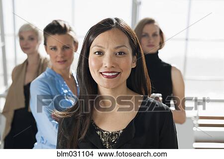 Businesswomen smiling in office View Large Photo Image Picture - Businesswomen smiling in office. Fotosearch