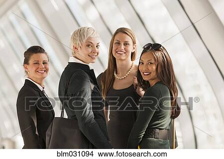 Picture - Businesswomen standing in lobby. Fotosearch