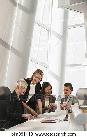 Stock Image - Businesswomen talking in meeting. Fotosearch