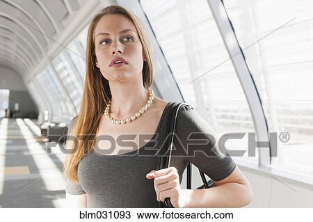 Stock Image - Caucasian businesswoman standing in lobby. Fotosearch