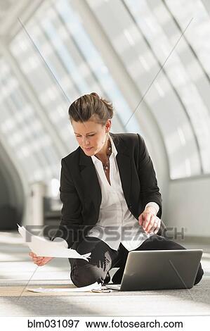 Caucasian businesswoman using laptop on lobby floor View Large Photo Image Stock Photo - Caucasian businesswoman using laptop on lobby floor. Fotosearch