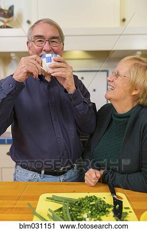 Stock Image - Caucasian couple cooking together in kitchen. Fotosearch