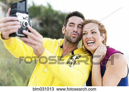 Caucasian couple taking self-portrait with vintage camera View Large Photo Image Stock Image - Caucasian couple taking self-portrait with vintage camera. Fotosearch