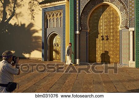 Stock Photograph - Caucasian man taking picture of man by ornate temple. Fotosearch
