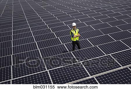 Stock Photography - Caucasian technician smiling on solar panels. Fotosearch