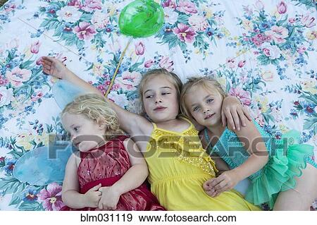 Stock Photo - Girls laying on blanket together. Fotosearch