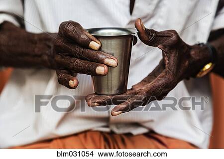 Picture - Man's hands holding cup of tea. Fotosearch