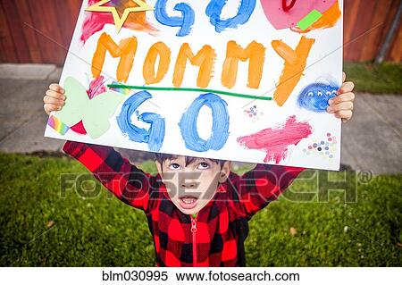 Stock Photography - Mixed race boy holding Go mommy go sign. Fotosearch