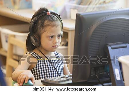Stock Photo - Mixed race Down syndrome student using computer. Fotosearch
