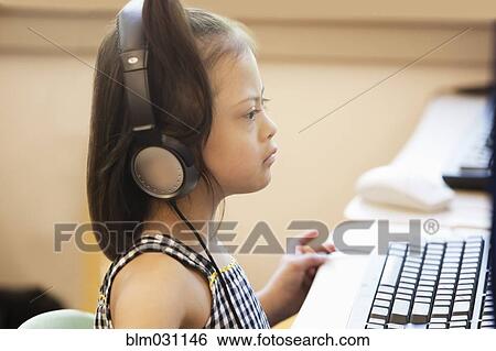 Stock Photograph - Mixed race Down syndrome student using computer. Fotosearch