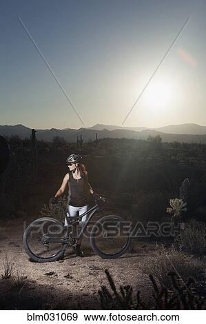Mountain biker standing in desert View Large Photo Image Stock Photo - Mountain biker standing in desert. Fotosearch