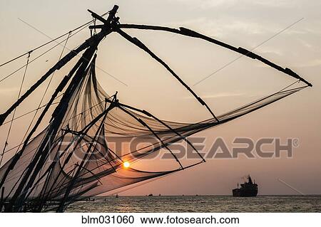Stock Image - Silhouette of fishing nets at sunset. Fotosearch
