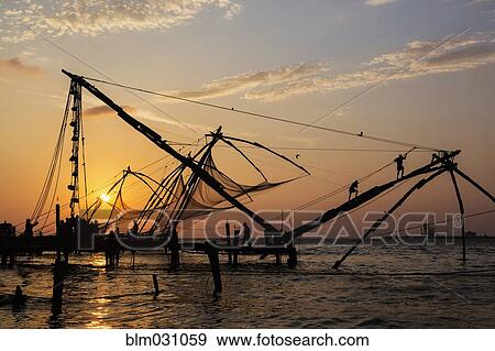 Stock Photo - Silhouette of fishing nets at sunset. Fotosearch