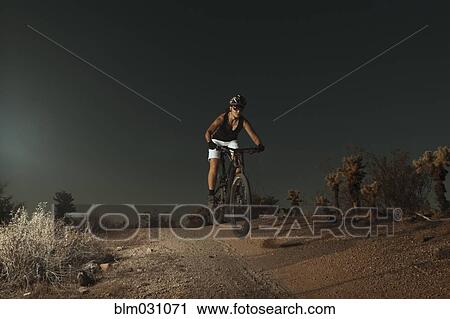 Woman riding mountain bike in desert View Large Photo Image Stock Image - Woman riding mountain bike in desert. Fotosearch
