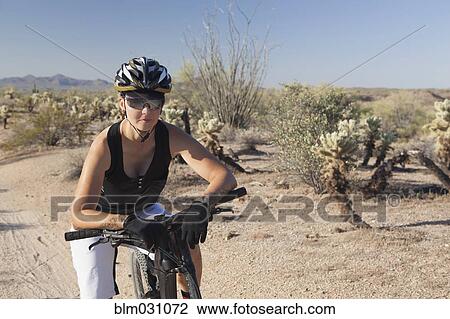 Woman riding mountain bike in desert View Large Photo Image Stock Image - Woman riding mountain bike in desert. Fotosearch