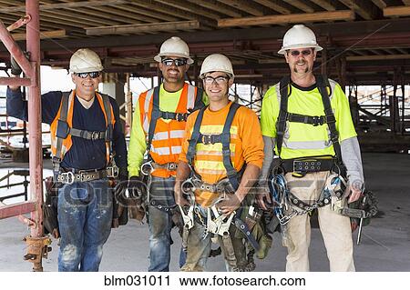 Workers smiling at construction site View Large Photo Image Stock Image - Workers smiling at construction site. Fotosearch