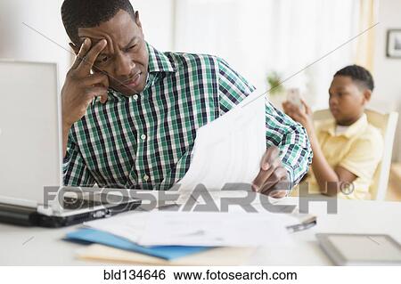 Anxious father paying bills online View Large Photo Image Stock Photograph - Anxious father paying bills online. Fotosearch