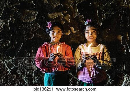 Asian girls holding candles in temple View Large Photo Image Stock Image - Asian girls holding candles in temple. Fotosearch