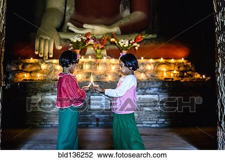 Asian girls lighting candles in Buddhist temple View Large Photo Image Stock Image - Asian girls lighting candles in Buddhist temple. Fotosearch