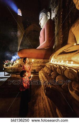 Asian mother and daughter lighting candles in temple View Large Photo Image Stock Image - Asian mother and daughter lighting candles in temple. Fotosearch