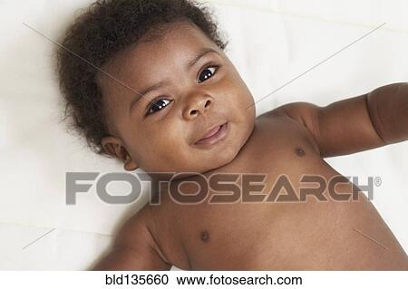 Black baby laying on bed View Large Photo Image Stock Image - Black baby laying on bed. Fotosearch