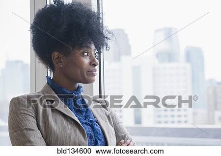 Black businesswoman looking out office window View Large Photo Image Stock Image - Black businesswoman looking out office window. Fotosearch