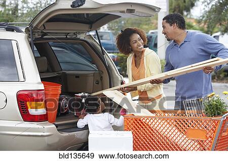 Stock Photo - Black family loading car at home improvement store. Fotosearch