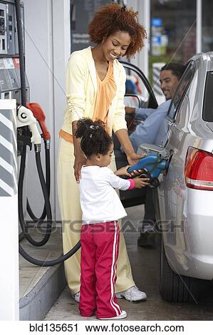 Black mother teaching daughter to pump gas View Large Photo Image Stock Image - Black mother teaching daughter to pump gas. Fotosearch
