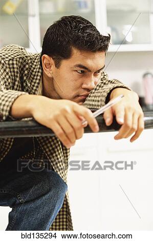 Bored man laying on counter top View Large Photo Image Picture - Bored man laying on counter top. Fotosearch