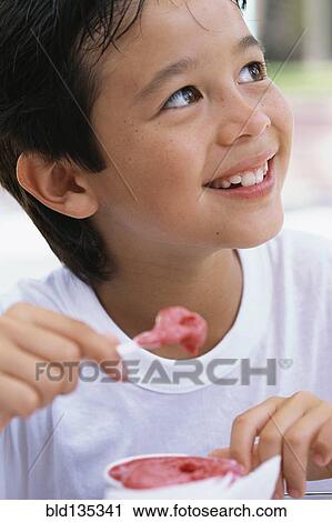 Boy eating ice cream outdoors View Large Photo Image Stock Image - Boy eating ice cream outdoors. Fotosearch