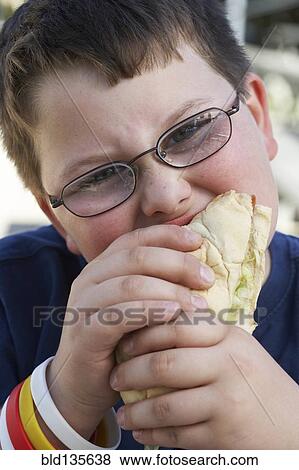 Boy eating sandwich outdoors View Large Photo Image Stock Photo - Boy eating sandwich outdoors. Fotosearch