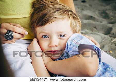 Boy laying in mother's lap View Large Photo Image Stock Image - Boy laying in mother's lap. Fotosearch