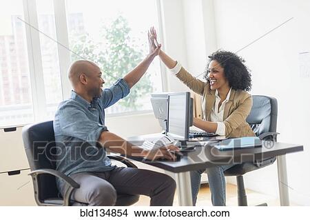 Business people high fiving in office View Large Photo Image Picture - Business people high fiving in office. Fotosearch