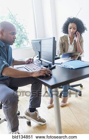 Stock Image - Business people working in office. Fotosearch