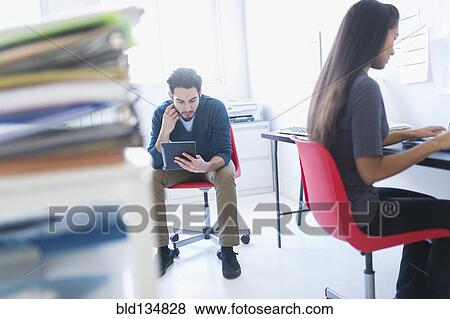 Stock Photo - Business people working in office. Fotosearch